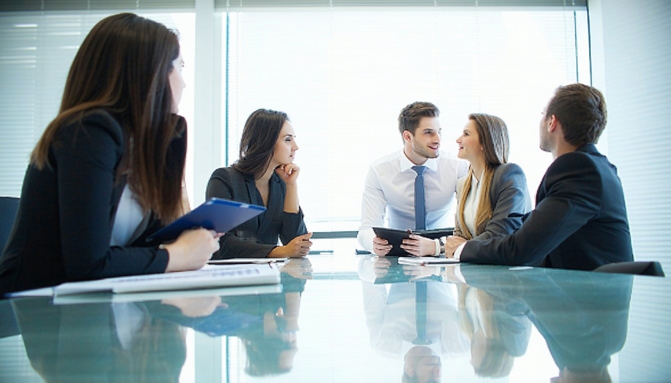 image of employees sitting around a conference room table